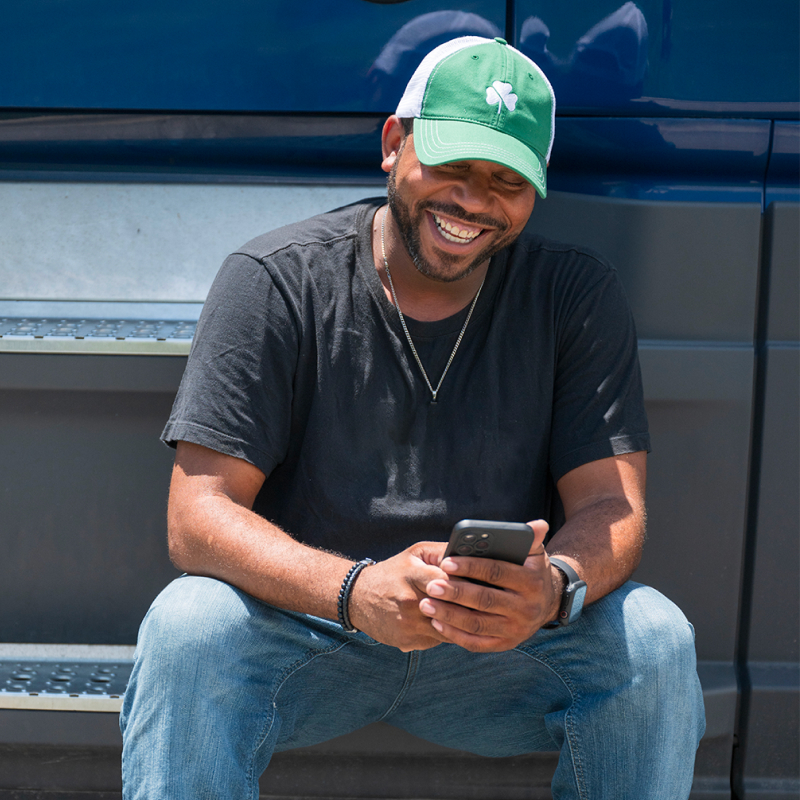a smiling truck driver using a smartphone
