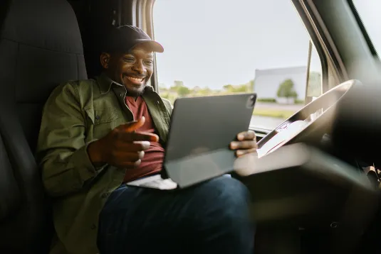Truck driver looking at a tablet. 
