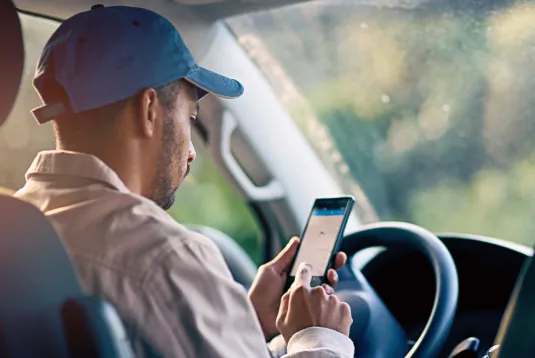 Trucker looking at a phone. 