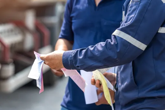 Two truck drivers looking at paperwork. 