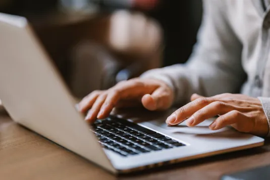 Person typing on a laptop. 