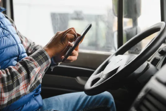 Person in truck looking at phone. 