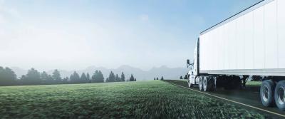 Truck driving down road with mountains in sight