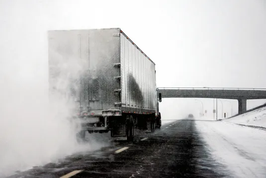 Truck on an icy and snowy road.