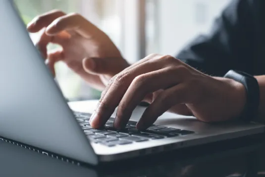 Person typing on a laptop.
