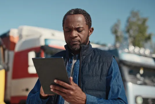 Truck driver looking at a tablet.